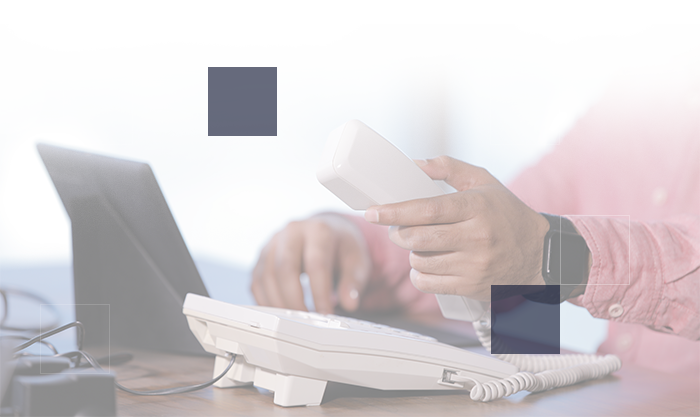 Hands dialing a desk phone